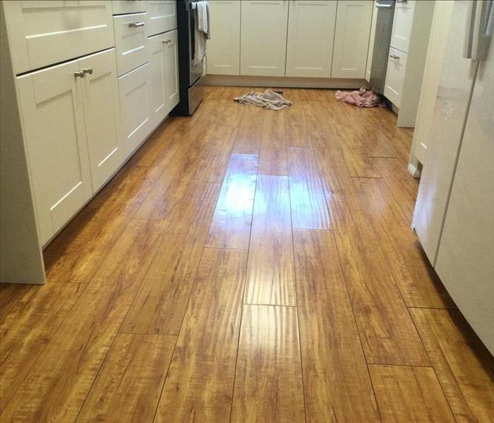 wood flooring with white cabinets on the side 