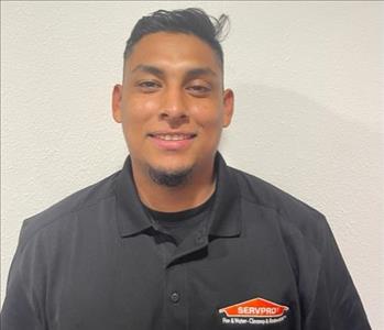 man with black shirt standing in front of a white wall 