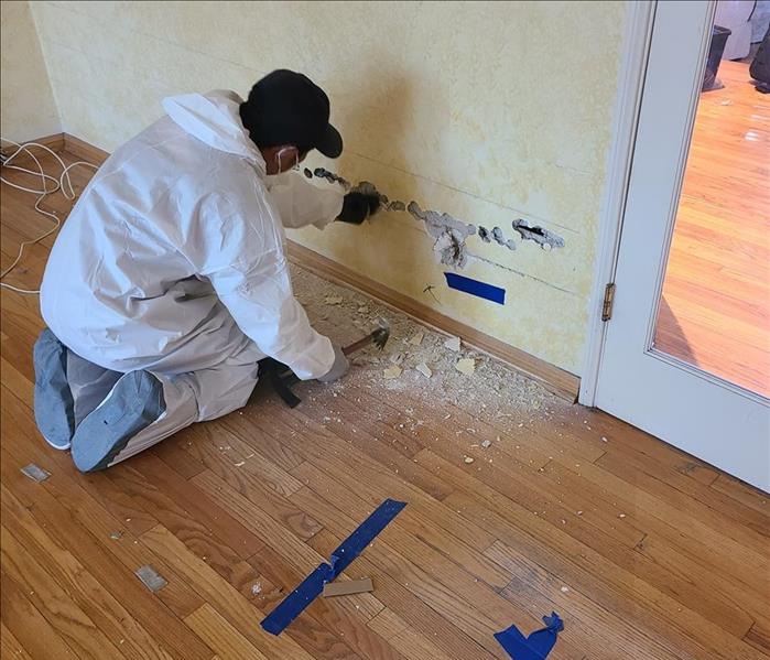 male wearing a white suit demoing a wall 