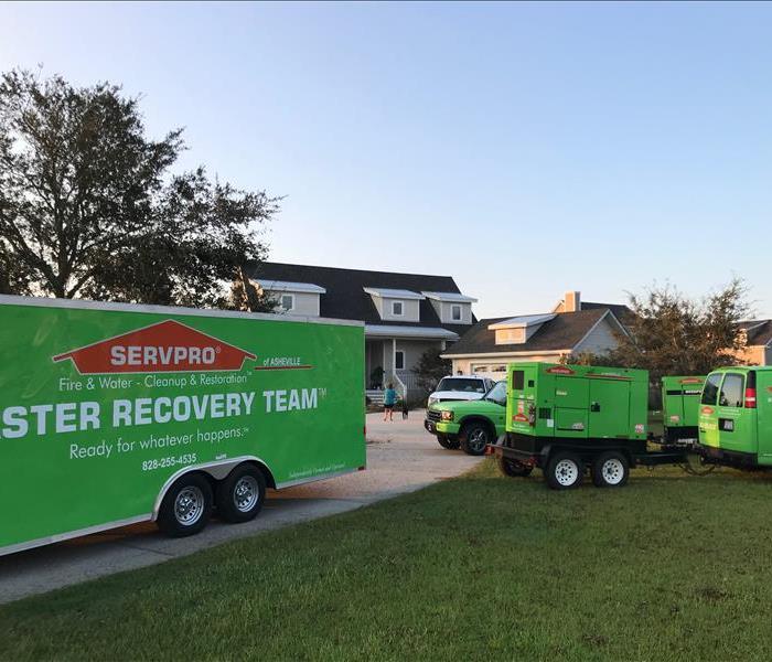 servpro team and trucks parked outside of a house 